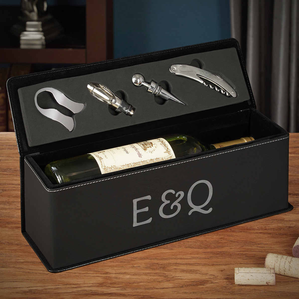 Black wine box holding a bottle, with corkscrew and bottle opener tools in lid and “E&Q” on front.