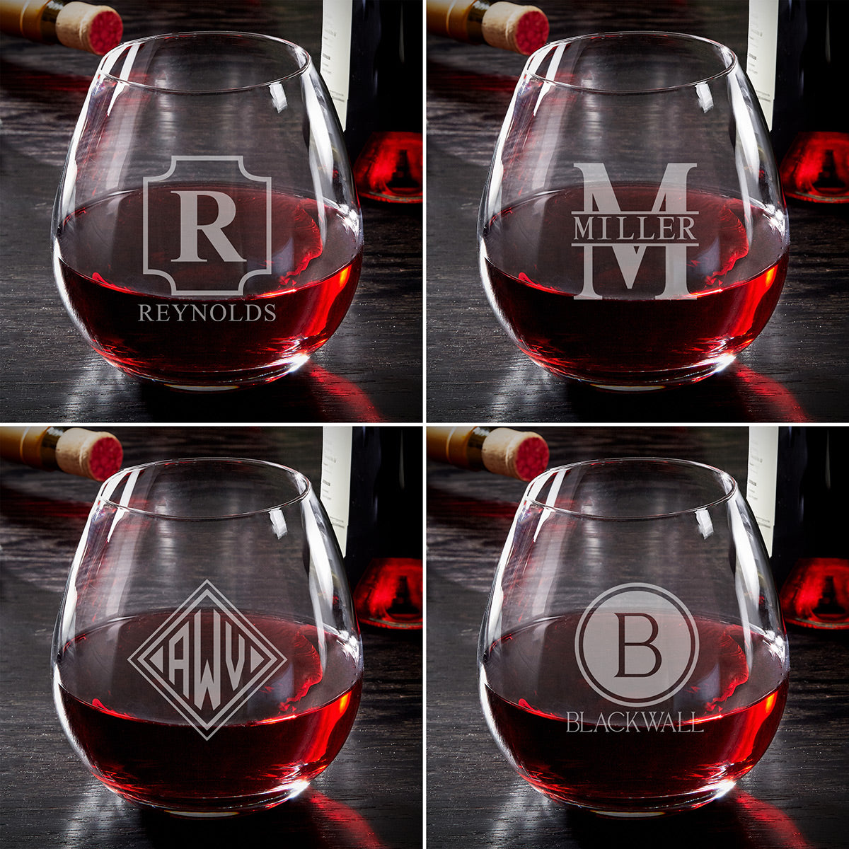 Four wine glasses with red wine, each etched with a different monogram, with wine bottles in the background.