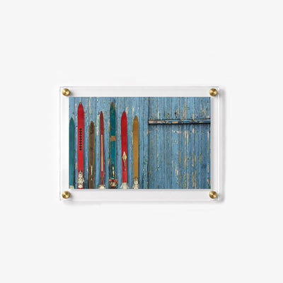 Acrylic wall art featuring vintage skis and a weathered blue wood backdrop