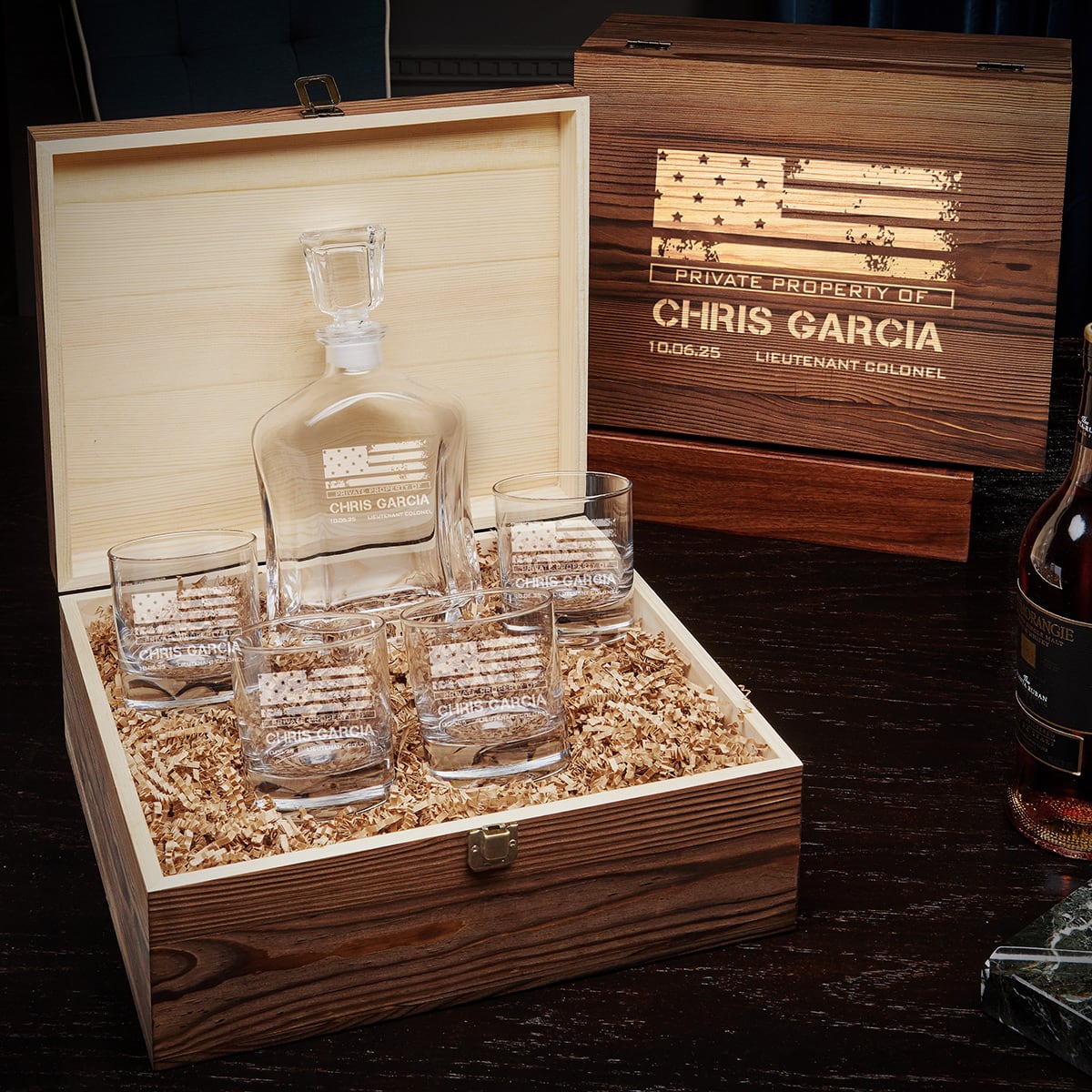 Open wooden gift box with etched decanter and four glasses; second wooden box behind reads “Private property of Chris Garcia”.
