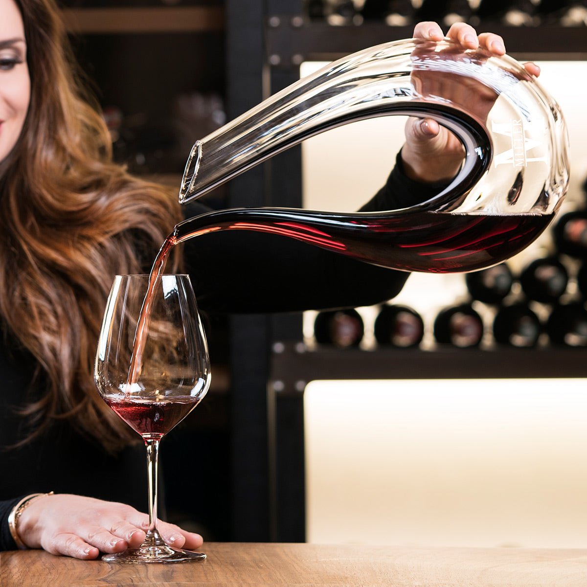 woman with a dolcetto decanter pouring red wine into a glass