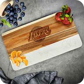 Wood cutting board with “Farmer’s Market” logo, blueberries, strawberries, orange slices, and a gray cloth on a countertop.