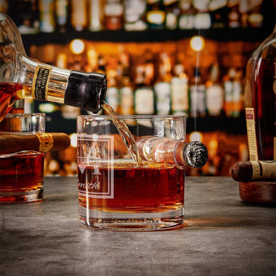 a bottle of whiskey being poured into the Oxley Round Cigar Glass