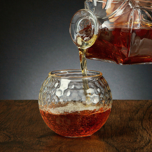 Decanter pouring whiskey on a Golf Ball Whiskey Glass