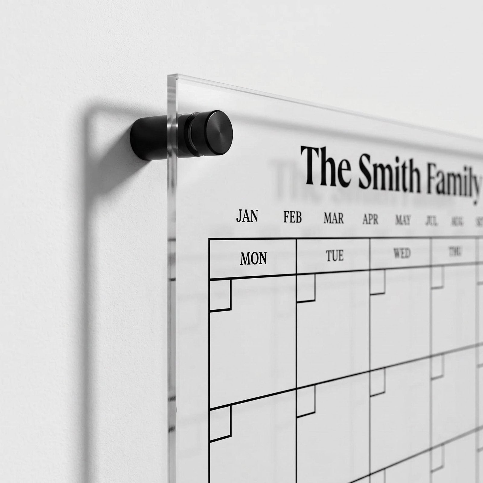 Close up of a personalized acrylic family wall calendar with black standoff