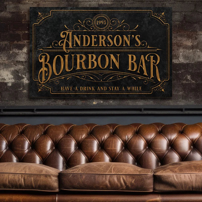 Vintage wall sign reading “Anderson’s Bourbon Bar” above a brown tufted leather sofa.